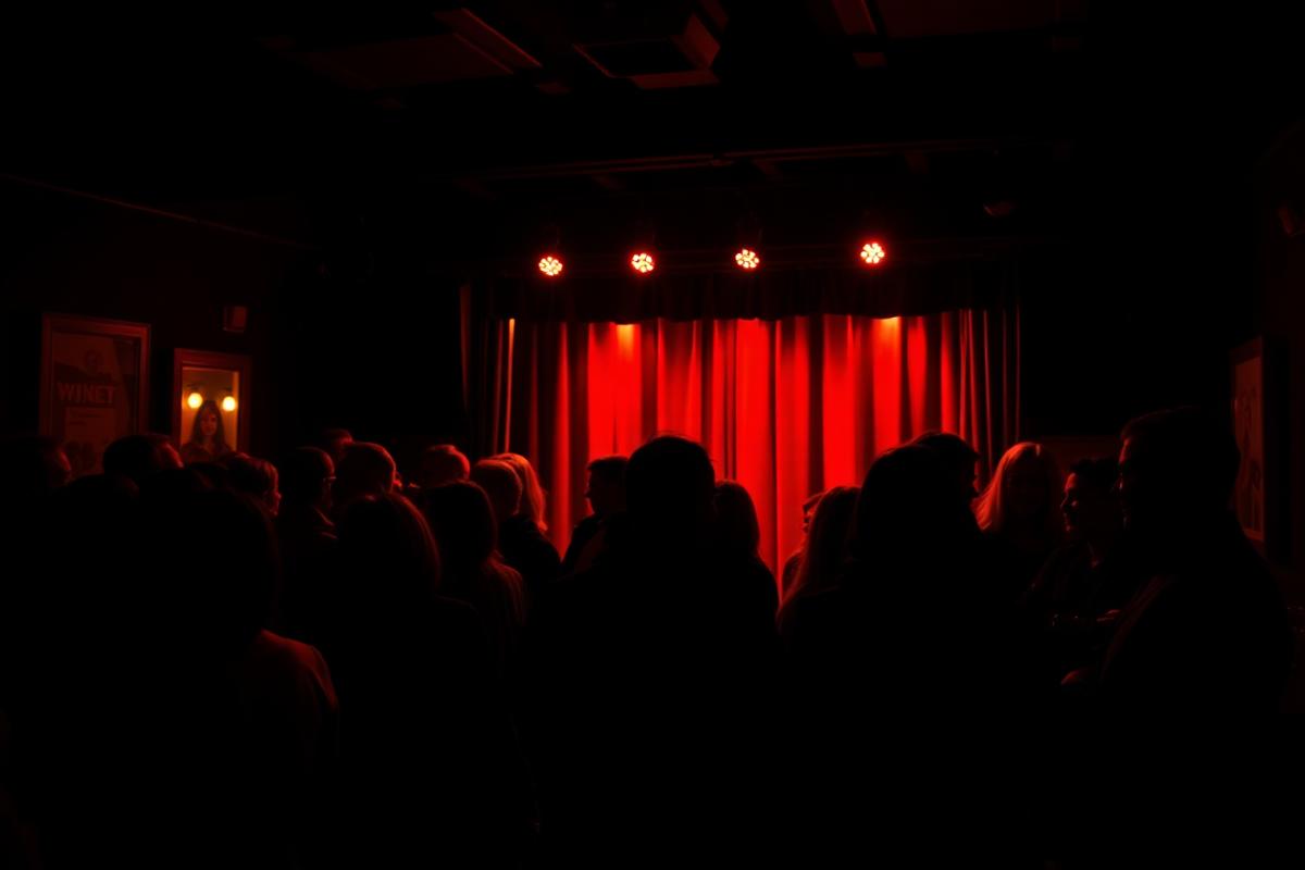 Minglande publik vid en kultur-AW med stand-up-scen i varmt rött ljus på Strömmen i Kalmar